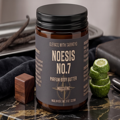 A jar of Noesis No.7 Masculine Parfum Body Butter on a dark marble surface, styled with a wooden block, a sliced lime, and vanilla beans in the background.
